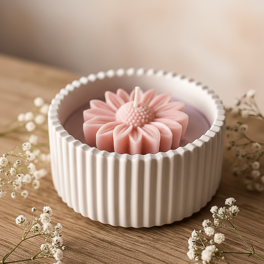 Vela de soja artesanal con detalle de margarita en relieve dentro de un cuenco estriado de resina blanca, estilo minimalista cálido.