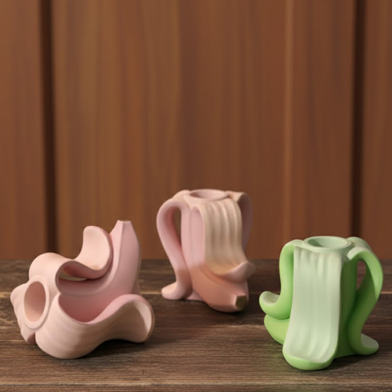 Colección de portavelas artesanales con forma de plátano en colores rosa y verde pastel, piezas de decoración  sostenible y personalizable para un hogar minimalista.
