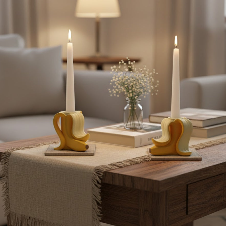 Decoración de salón con portavelas de plátano amarillos sobre camino de mesa de lino, rodeados de libros y flores secas para un ritual de desconexión y slow living.